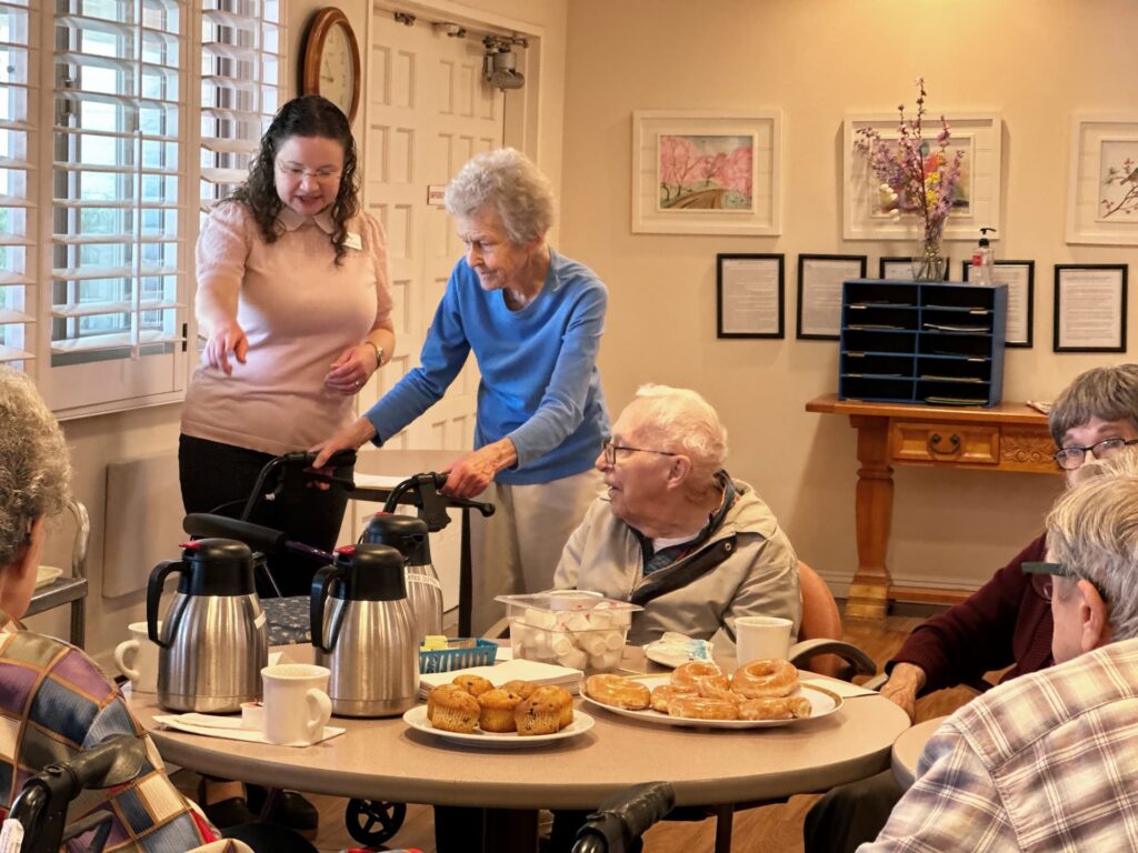 Woman helping elderly with breakfast